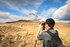 Person observing wildlife with binoculars during a hike in the Portería del Lago Sarmiento sector, Torres del Paine.