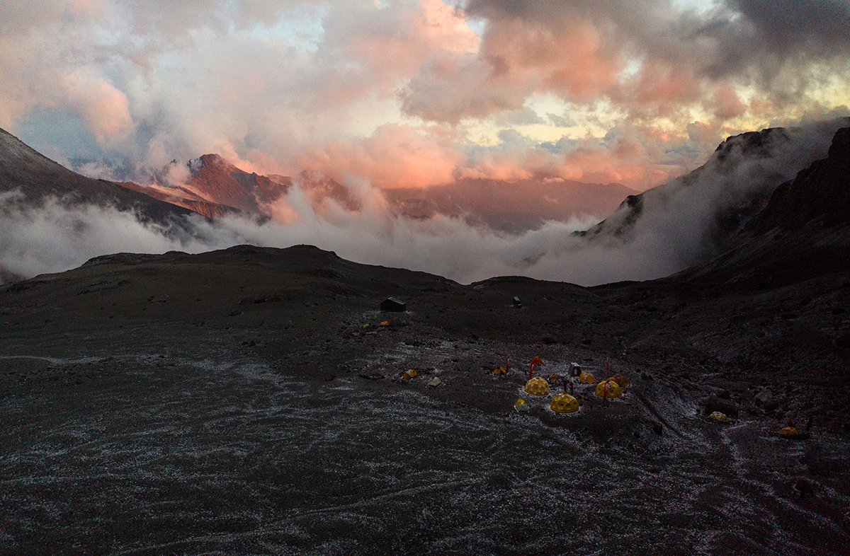 View of Campamento Federación on Cerro El Plomo at dawn, surrounded by mountains and clouds in the Andes Mountains, Chile