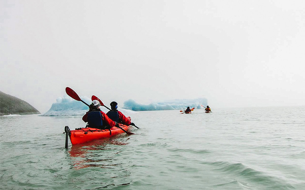 Group of kayakers paddling among icebergs on Lake Grey, in front of the Grey Glacier in Torres del Paine, Chilean Patagonia.