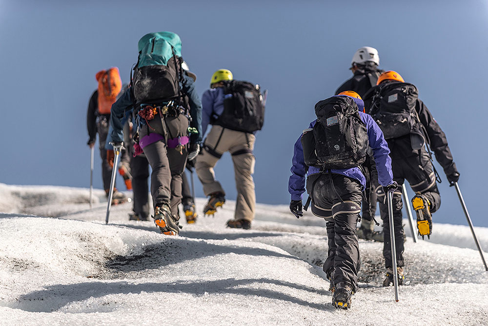 Group of travelers doing the ice hike on the Grey Glacier in Torres del Paine, equipped with crampons and ice axes.