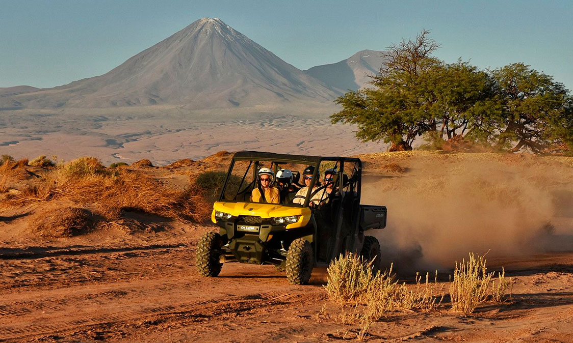 Couple enjoying a buggy tour through the Atacama Desert in San Pedro de Atacama at sunset.