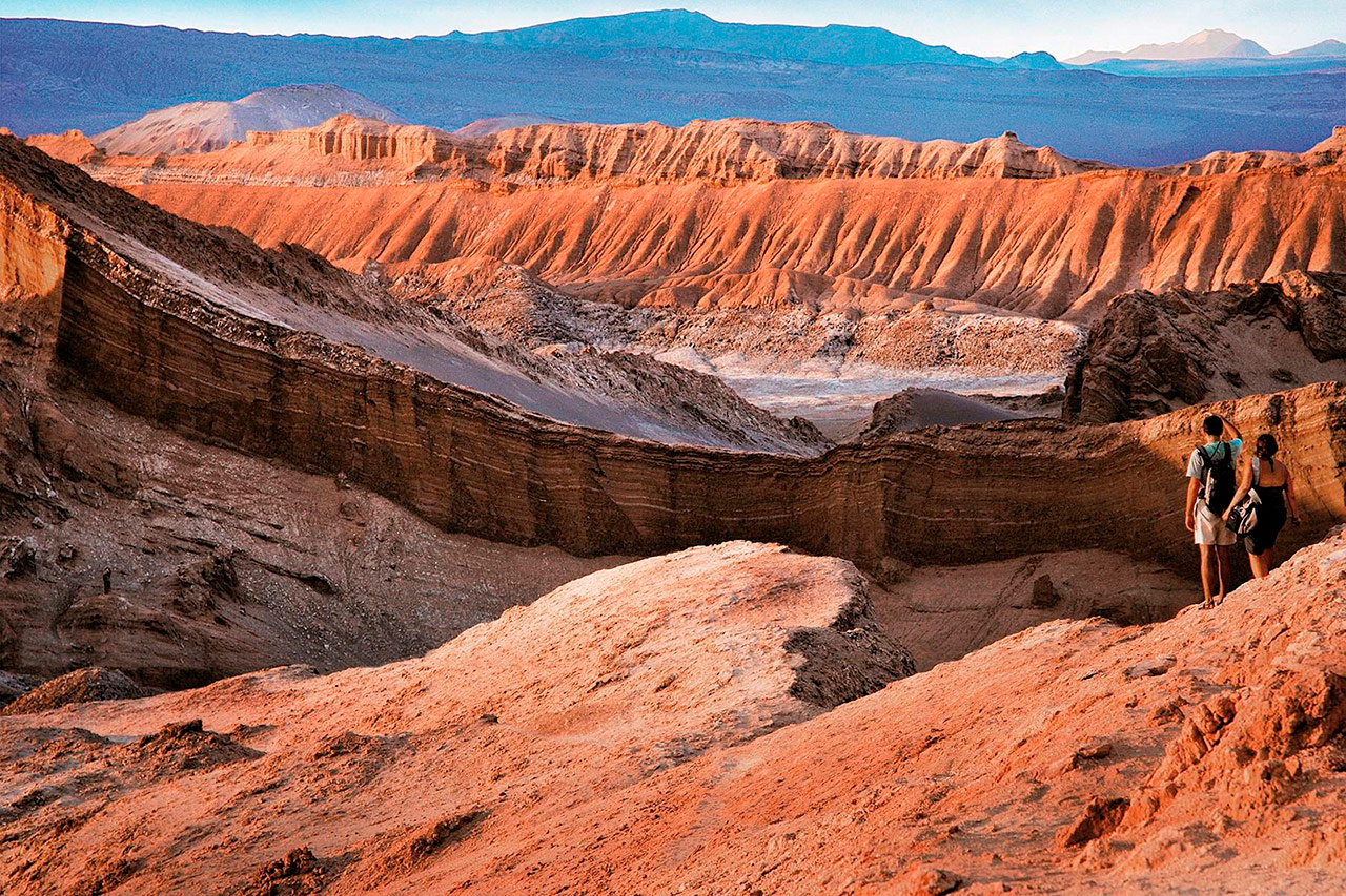 Couple contemplating Valle de la Luna at sunset in San Pedro de Atacama.