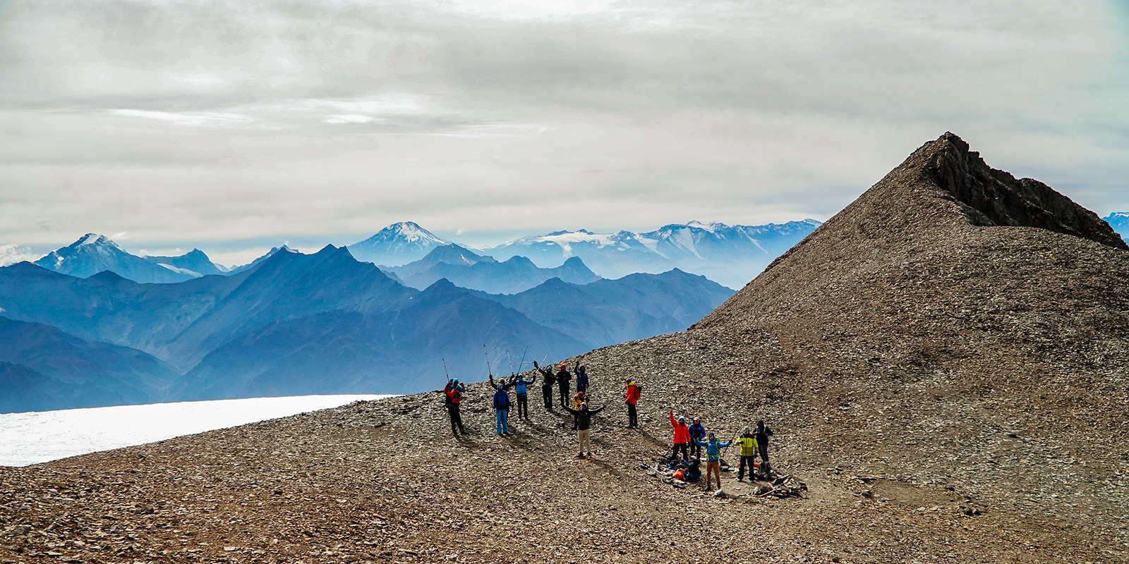 Group of mountaineers celebrating at the summit of Cerro El Plomo, overlooking the Andes Mountains in Chile
