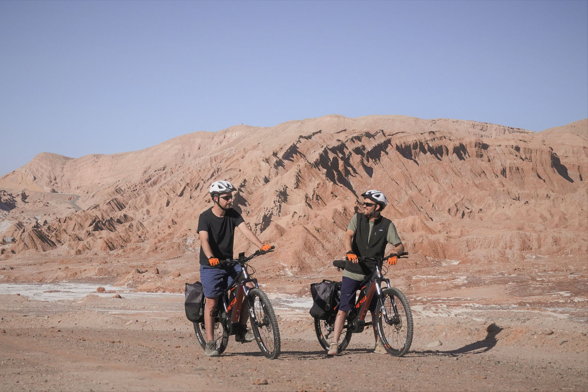 Cyclists touring the arid landscapes of San Pedro de Atacama on an electric bicycle tour under the clear desert sky.