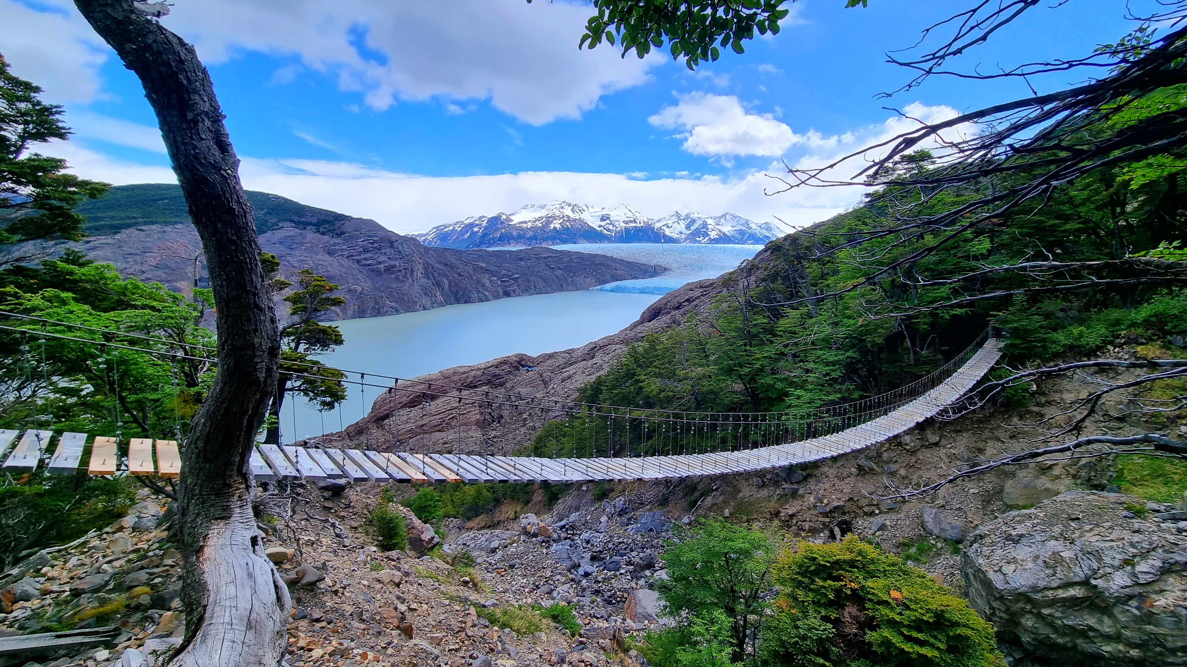Hanging bridge of Paso John Gardner overlooking Glaciar Grey and the snowy mountains in Torres del Paine National Park.
